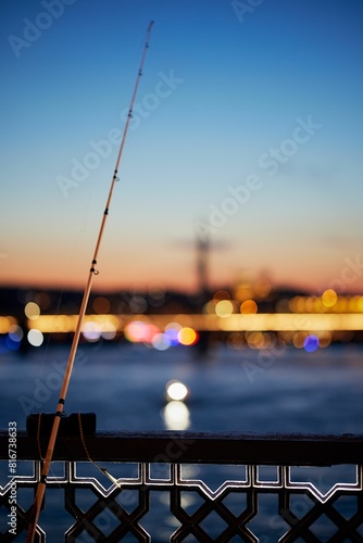 Photography Metal rod against the Galata bridge railing on a tranquil sunset backdrop in Ist