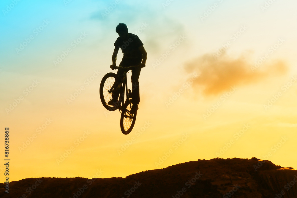 Obraz premium An extreme man jumping on the trial bicycle in the mountains.