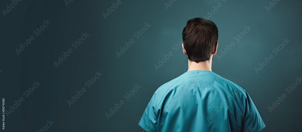 A young Caucasian doctor man in blue medical uniform seen from the back in a studio shoot description of the back side view of a doctor wearing a blue medical uniform in a studio shoot A young Caucasian doctor man in blue medical uniform seen from the back in a studio shoot description of the back side view of a doctor wearing a blue medical uniform in a studio shoot