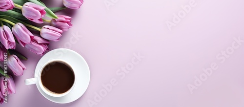 A top view copy space image showcasing a pink background adorned with a vibrant arrangement of purple tulips accompanied by a cup of coffee The white emptiness enhances the overall aesthetics of the #816743842