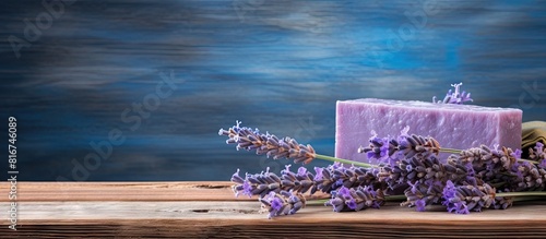 A worn blue painted wooden table provides the backdrop for a copy space image of lavender soap and flowers