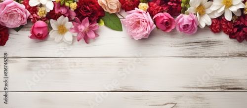 Vintage floral arrangement on a white wooden surface The pink and red flowers bring a touch of color to the copy space image © vxnaghiyev
