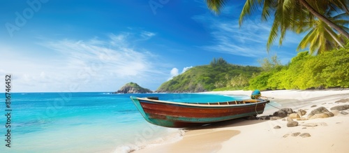 A scenic tropical seascape with a boat resting on the sandy beach creating a perfect copy space image