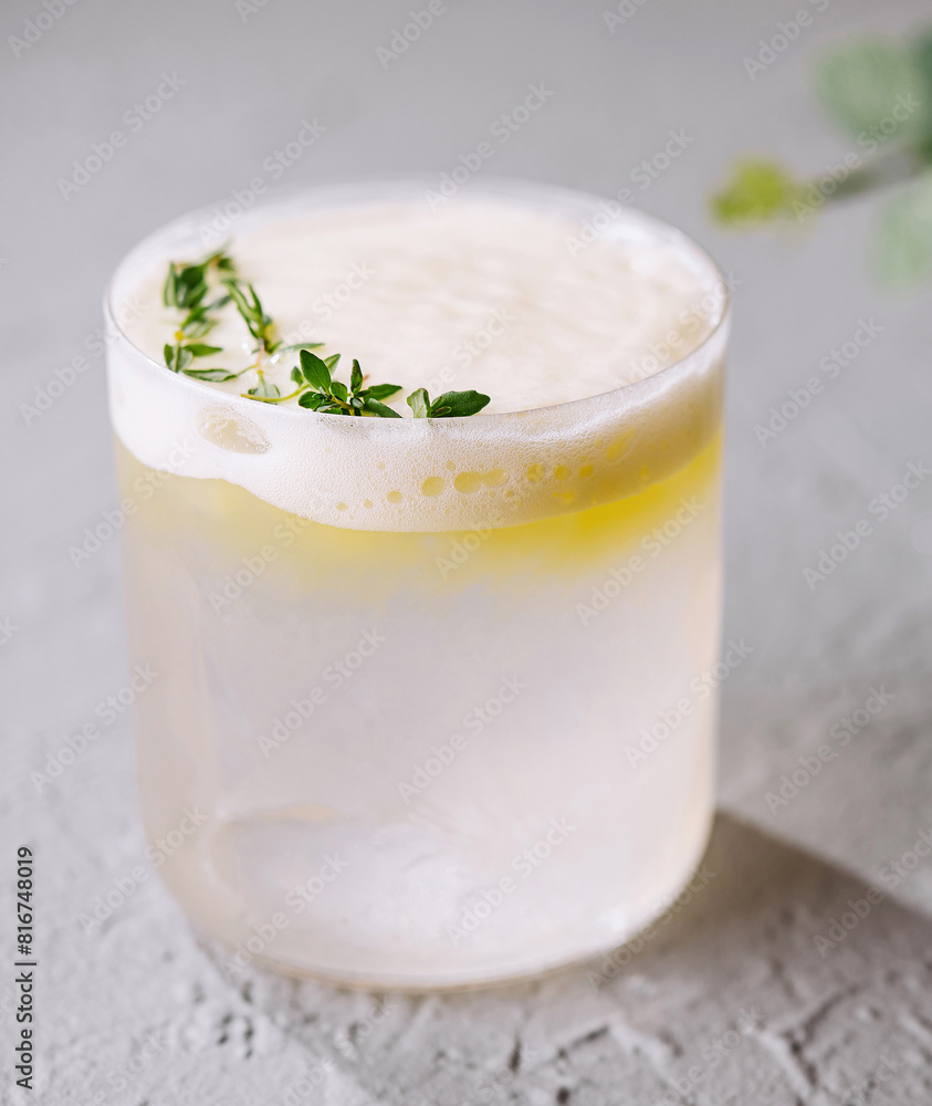 Refreshing lemon cocktail with thyme garnish Refreshing lemon cocktail with thyme garnish