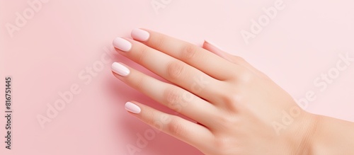 High resolution widescreen image featuring a pink background adorned with the elegant beauty of female fingers showcasing a beautiful manicure Ample copy space available
