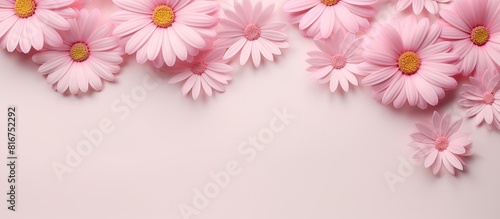 A frame background in pastel pink featuring daisy flowers and leaves in a flat lay arrangement Perfect for spring or summer social media mockups with available copy space © StockKing