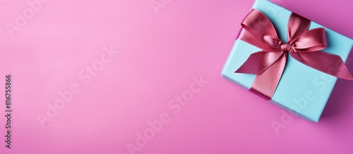 Gift box with ribbon and bow on color background and space for text Top view. copy space available