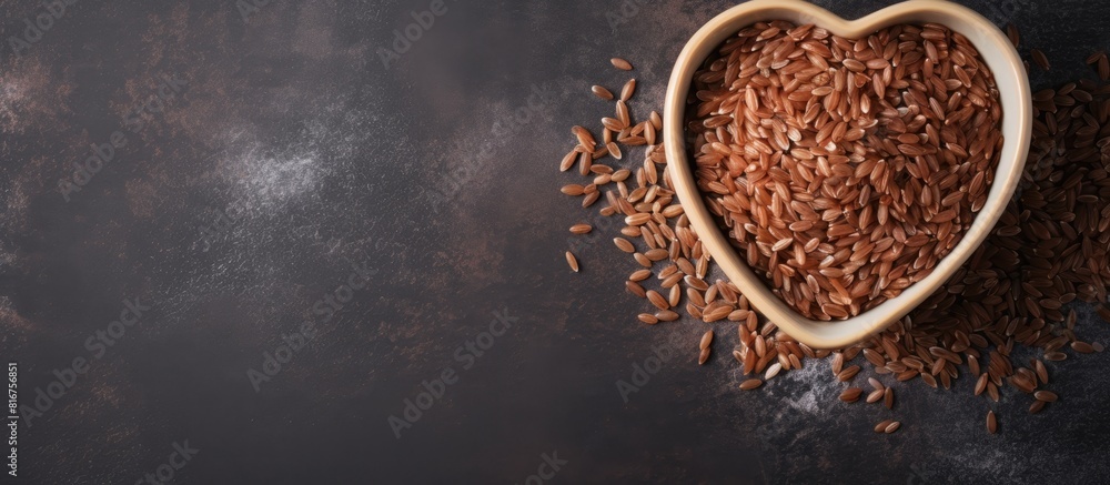 Brown rice in heart shaped bowl on gray cement background Copy space Top view or flat lay Brown rice in heart shaped bowl on gray cement background Copy space Top view or flat lay