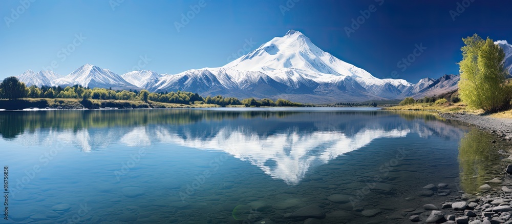 Scenic nature landscape of lake with snow capped mountain and blue sky views. copy space available