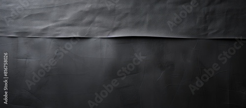 Black creased piece of matte cloth adheisive gaffer tape on grey cardboard background Copy space for text photo