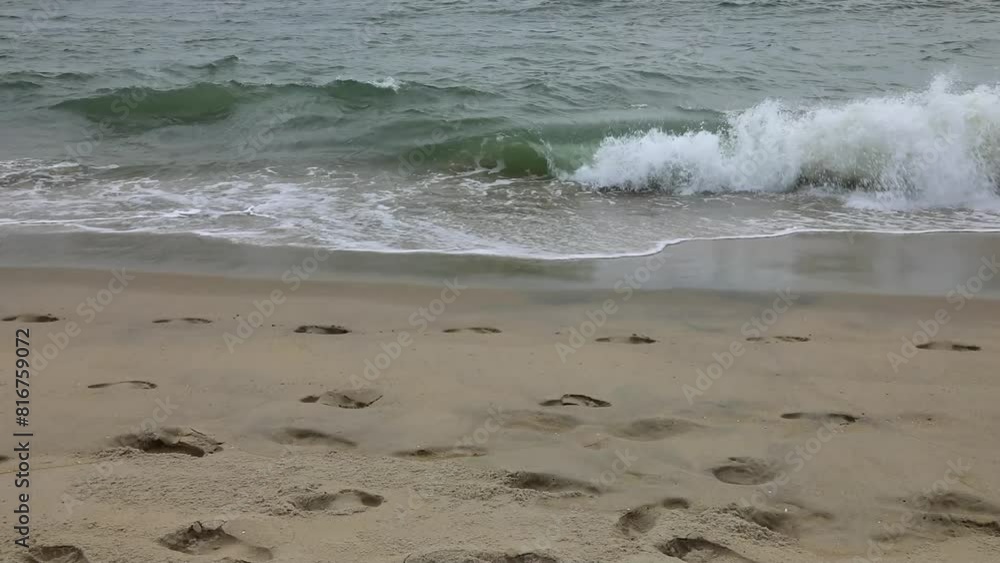 Atlantic Ocean waves wipe away the footprints on the sandy Bethany beach in Delaware, USA Atlantic Ocean waves wipe away the footprints on the sandy Bethany beach in Delaware, USA