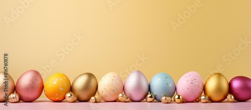 Creatively dyed decorative eggs in pastel colors decorated with gold leaf on yellow background copy space Happy Easter do it yourself concept Flat lay Horizontal photo