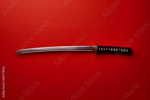 A high-quality photo of a traditional Japanese katana sword on a solid red background