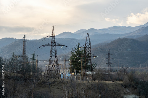 Power plant with high voltage lines. Wires for transmitting current on iron supports. Power lines. Transformers to provide region with electricity. Power plant in spring weather. Armenia, Dilijan photo