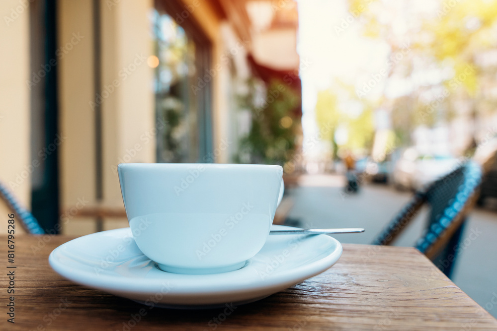 white single cup of coffee and saucer in sidewalk cafe white single cup of coffee and saucer in sidewalk cafe
