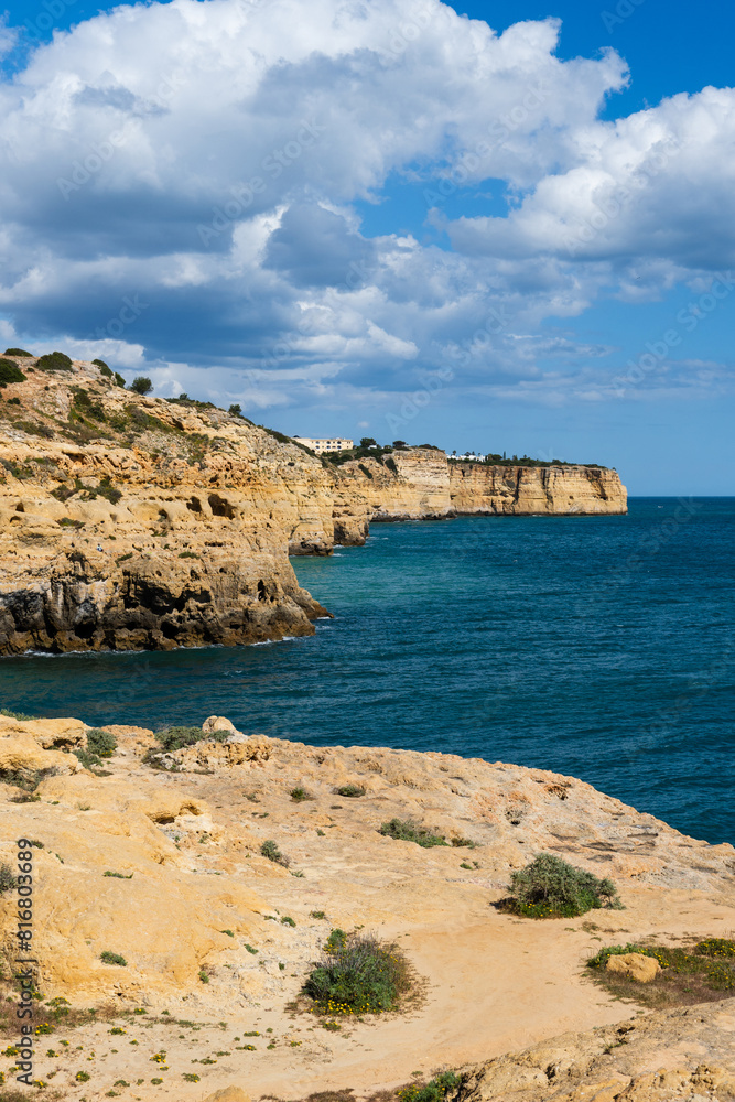 Algar Seco in Carvoeiro. Beautiful Golden Sandstone Rock Formation in Algarve with Atlantic Ocean in the Distance. Rocks, rocky shore, yellow rocks, coquina, beautiful coastline