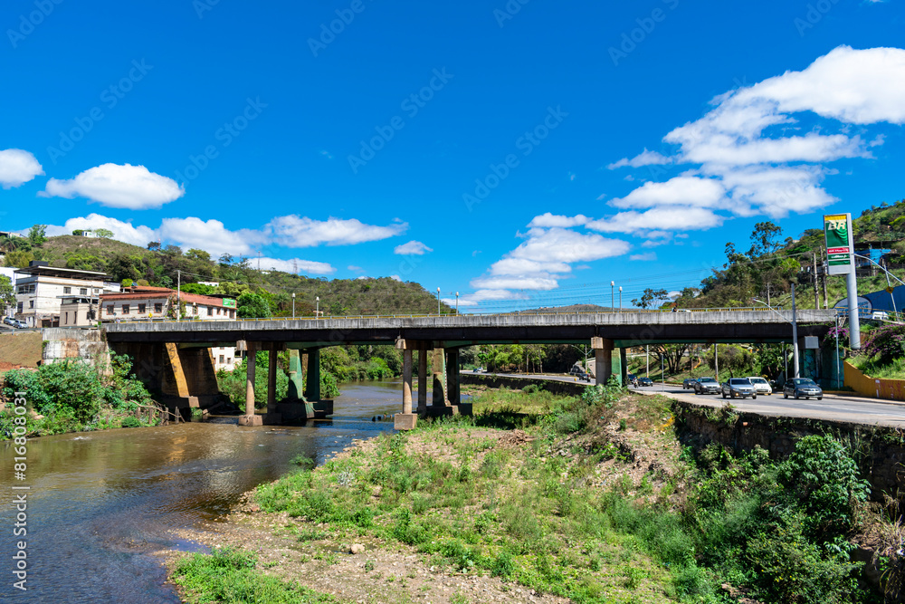 Partial view of the city of Sabará, Brazil. Streets, bridge, mountain, trees and blue sky with clouds. Partial view of the city of Sabará, Brazil. Streets, bridge, mountain, trees and blue sky with clouds.