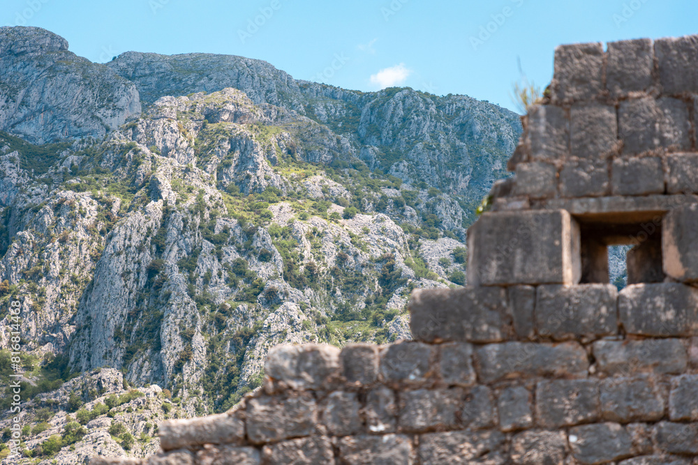 View from below of the old medieval ruined fortress of St. John in Kotor, Montenegro. Beautiful mountain landscape in background. Historic excursion at resort
