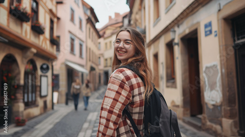 Garota viajante sorridente na rua da cidade velha da cidade europeia. Jovem turista mochileira gosta de viajar sozinha. Férias, férias, viagem, programa de intercâmbio, estilo de vida. photo