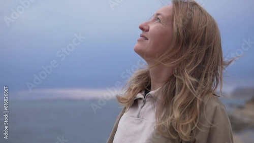 Close-up, slow motion, Woman averts her head and gaze towards the sky photo