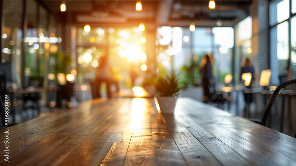 A wooden table in a busy business office is captured in a blurred state, showcasing the hustle and bustle of work happening around it A wooden table in a busy business office is captured in a blurred state, showcasing the hustle and bustle of work happening around it