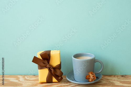 Obraz na płótnie Yellow gift box and cup of latte coffee on wooden table. mint wall background w salonie
