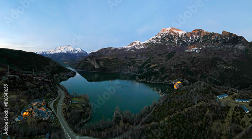 Aerial views of the Búbal reservoir in the province of Huesca with the snow-capped Pyrenees in the background during a sunny day photo