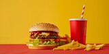 A cheeseburger, fries, and a soft drink on a red table against a yellow background.
