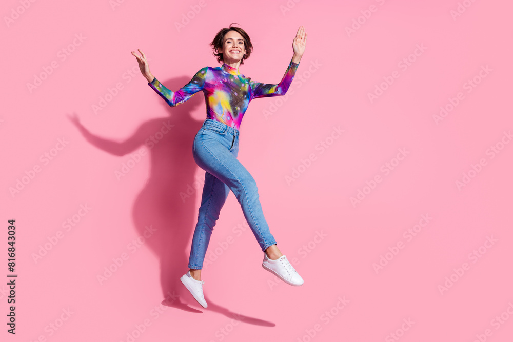Full body portrait of pretty girl jumping empty space wear pullover isolated on pink color background Full body portrait of pretty girl jumping empty space wear pullover isolated on pink color background