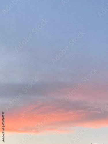 Beautiful sunset sky with pastel pink and blue hues. Soft clouds create a soothing and peaceful atmosphere, capturing the tranquility of the evening