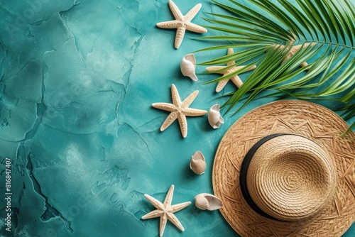 Beach hat with with seashell and starfish and palm leaf on green background.