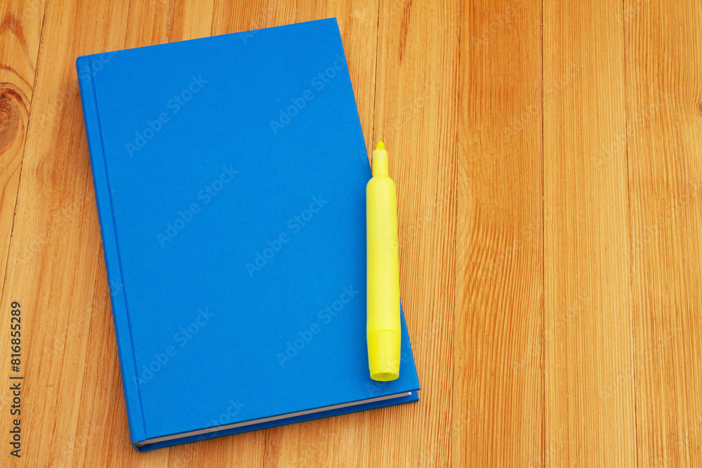 Retro old blue book with highlighter marker on a desk Retro old blue book with highlighter marker on a desk