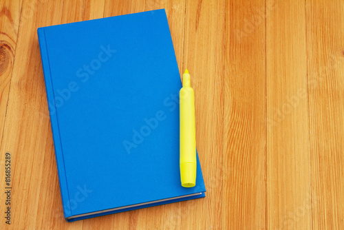 Retro old blue book with highlighter marker on a desk