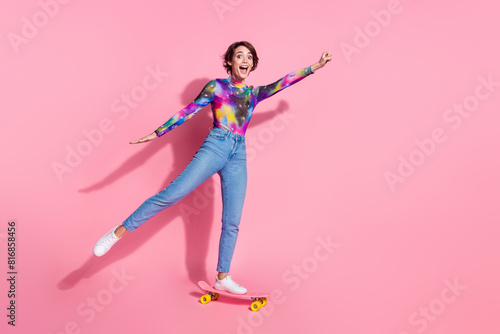 Full body portrait of pretty girl ride skate empty space wear pullover isolated on pink color background
