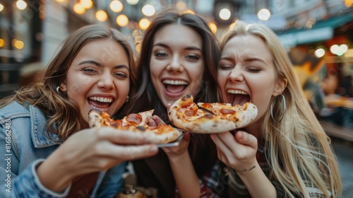 Group of three friends eat pizza and drink beer in a restaurant during their day break.