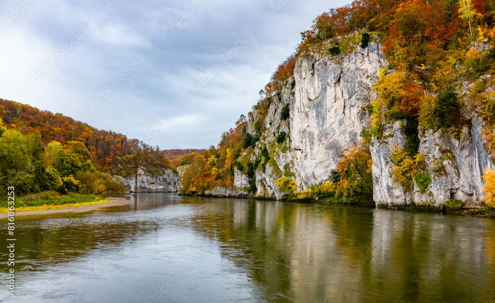Fototapeta premium Autumn panorama with colorful foliage, limestone rocks and Donau river near Kelheim (Bavaria, Germany). The famous “Weltenburger Enge“ narrows or Danube Gorge is natural reserve and tourist attraction