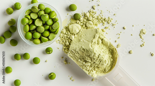 This image features green peas in a glass bowl and scattered around, alongside a scoop of green pea protein powder spread out on a white surface.