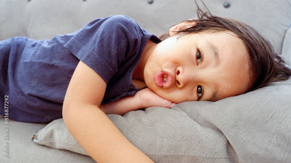 cute Asian toddler on the couch and making funny face cute Asian toddler on the couch and making funny face