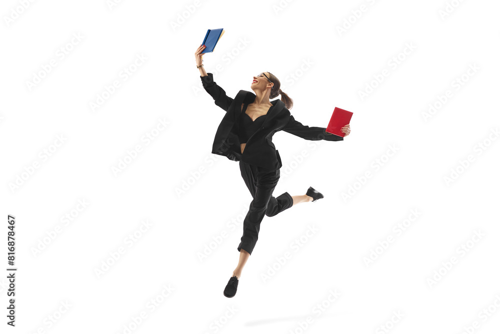 Fototapeta premium Businesswoman in mid-air pose, reading book in a jump, showcasing corporate success and continuous learning, isolated on white background. Concept of business, office lifestyle, professional growth