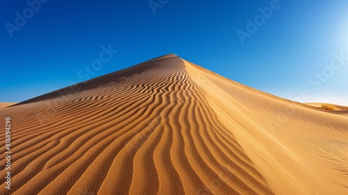 Desert dune under a blue sky with white clouds