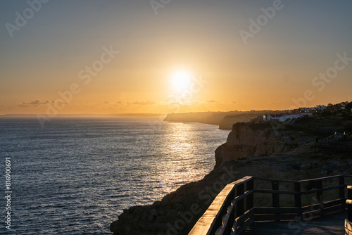 Algar Seco in Carvoeiro. Beautiful Golden Sandstone Rock Formation in Algarve with Atlantic Ocean in the Distance. Rocks, rocky shore, yellow rocks, coquina, beautiful coastline. Sunset.