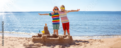 Boy and girl building on the beach sandcastle. Family vacation and tourism concept.