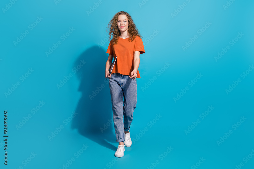 Photo of positive smiling girl with netbook go isolated blue color background Photo of positive smiling girl with netbook go isolated blue color background
