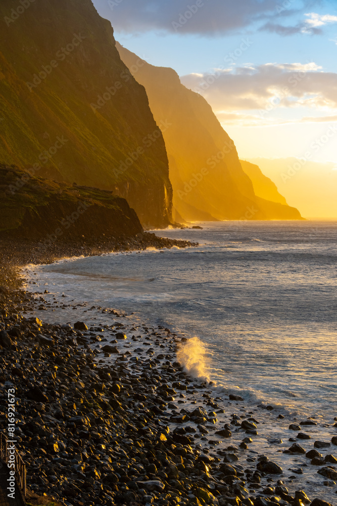 Volcanic rock cliffs Achadas da Cruz in backlit sunlight. Waves of the ...