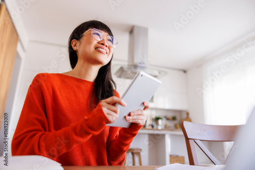 Woman working remotely from home using tablet computer