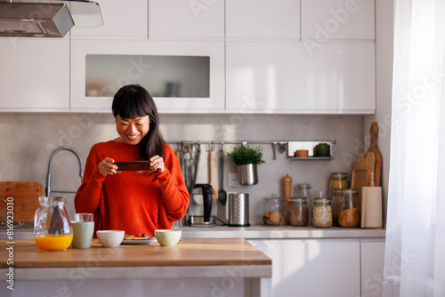 Woman photographing food while having breakfast