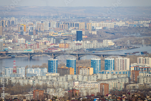 Krasnoyarsk city, Krasnoyarsk region, Siberia, Russia. Big Siberian city. View of many buildings and a road bridge across the Yenisei River. photo