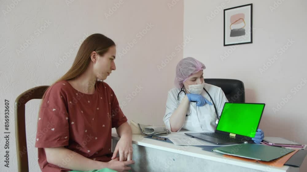 woman doctor and patient discussing something with green screen monitor in the hospital woman doctor and patient discussing something with green screen monitor in the hospital