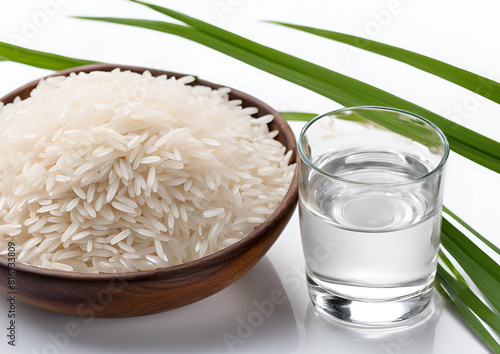 Close-up of rice ears isolated on white background next to a glass of water. photo