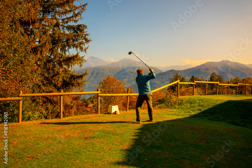 Wallpaper Mural Golfer Teeing Off with His Driver on Golf Course Menaggio with Mountain View in Autumn in Lombardy, Italy. Torontodigital.ca